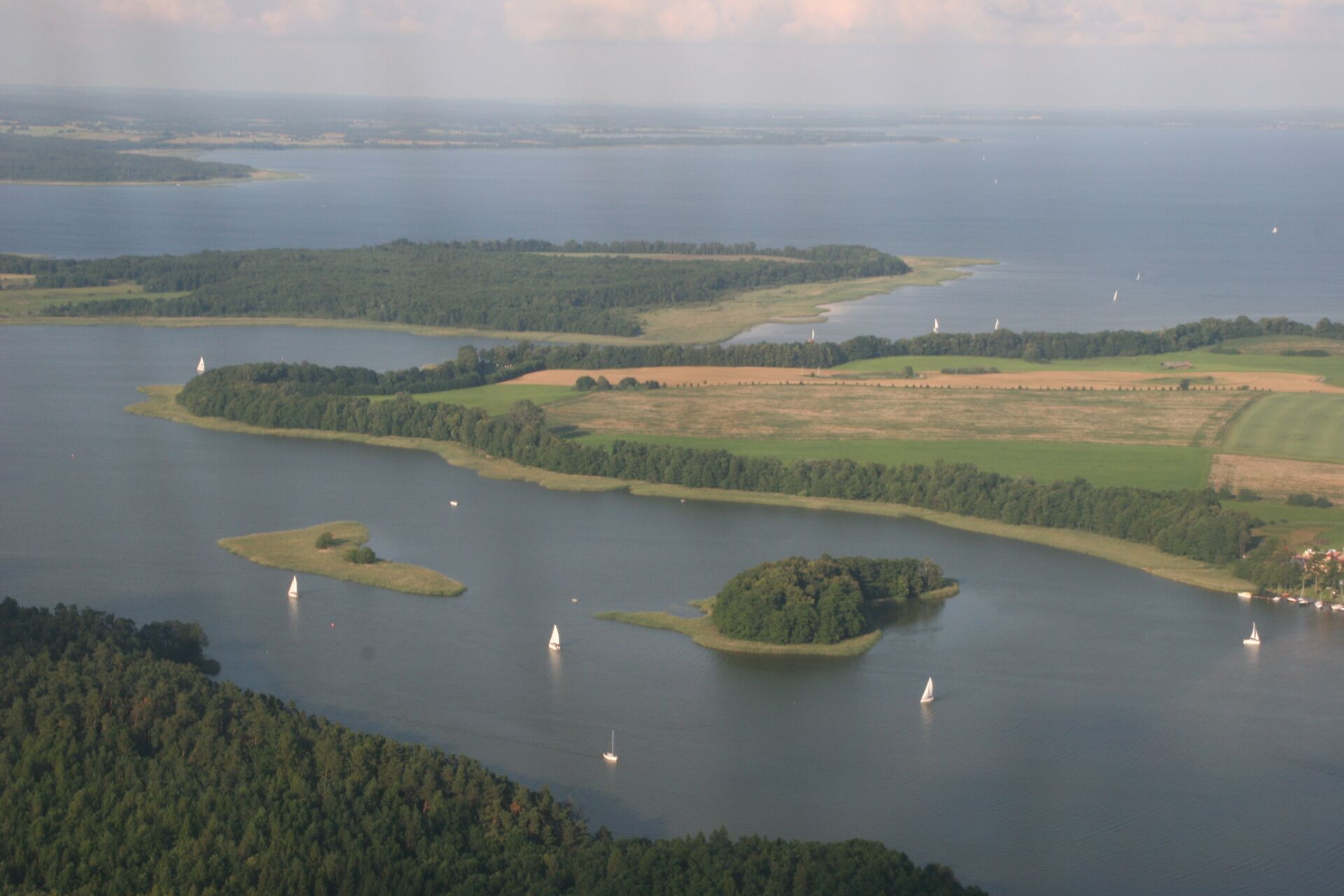 Eine Luftaufnahme von Masuren, die einen See und die umliegende Landschaft zeigt